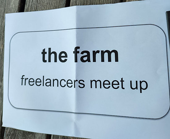 A sign printed on white paper reading The Farm freelancers meet up