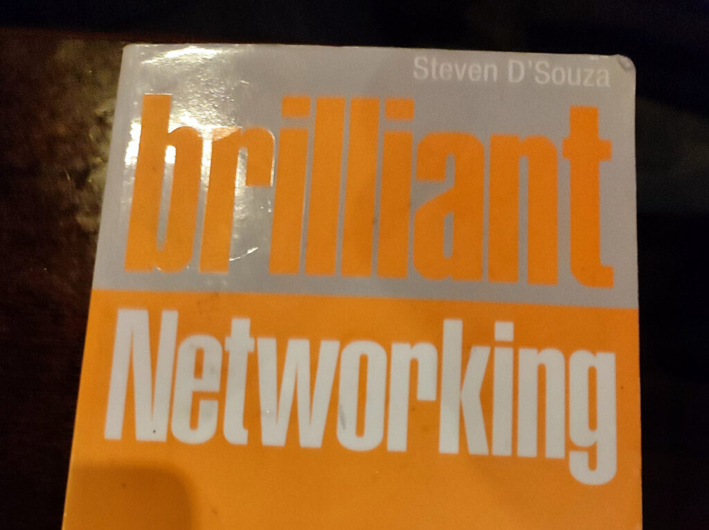 The top half of the book Brilliant Networking, which has a bright orange and silver colour, with orange and white writing on it